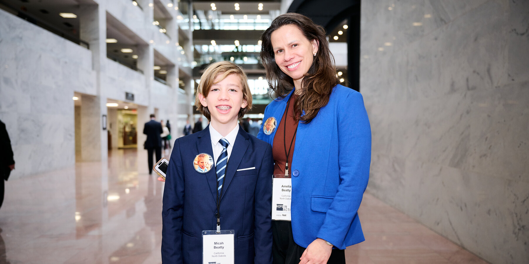 A young advocate and his mother in the atrium of a Senate office building